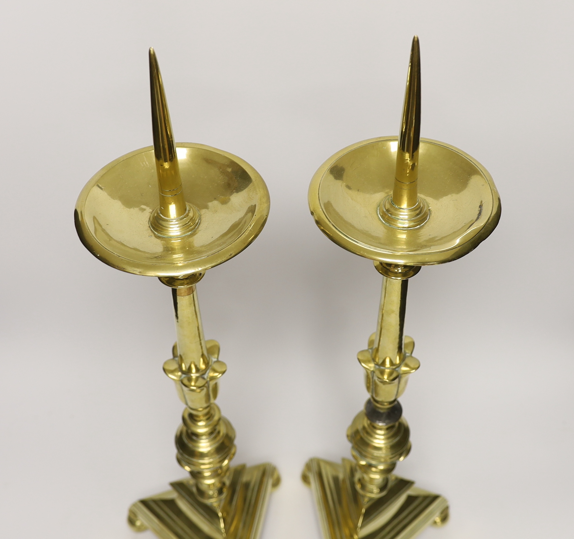 A pair of 17th Century Dutch brass pricket candlesticks, 58cm high